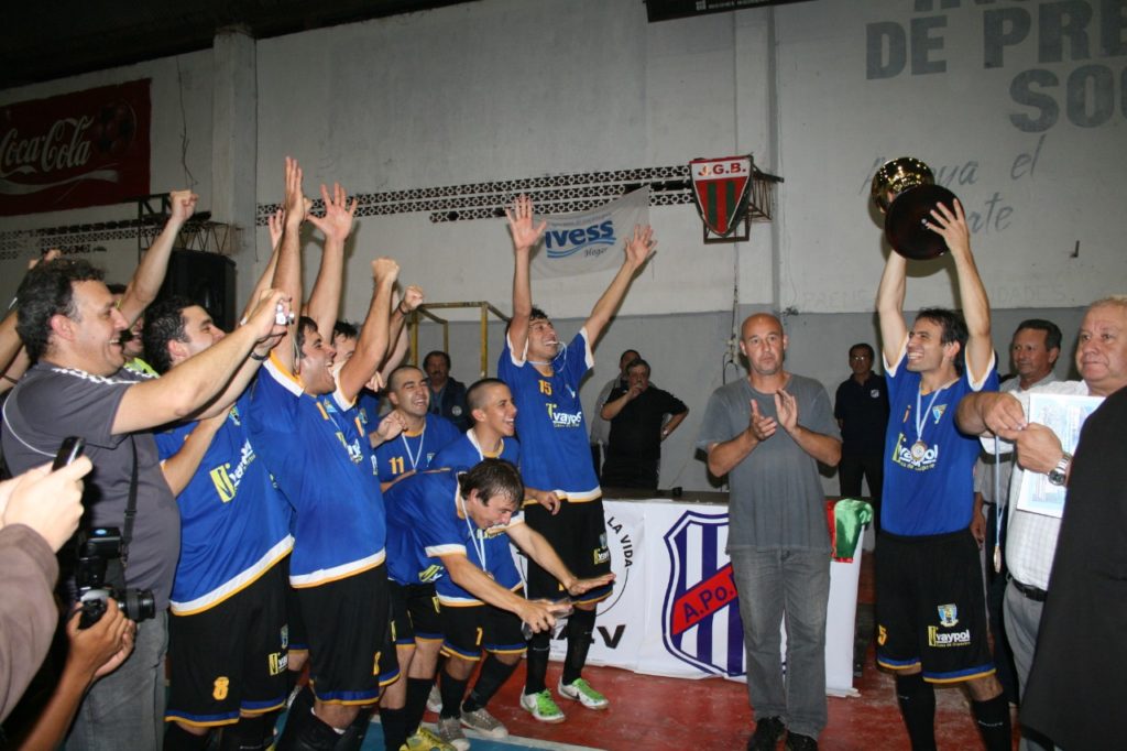 Rubén Novello levanta la copa y el resto del plantel festeja. Foto Solo Futsal
